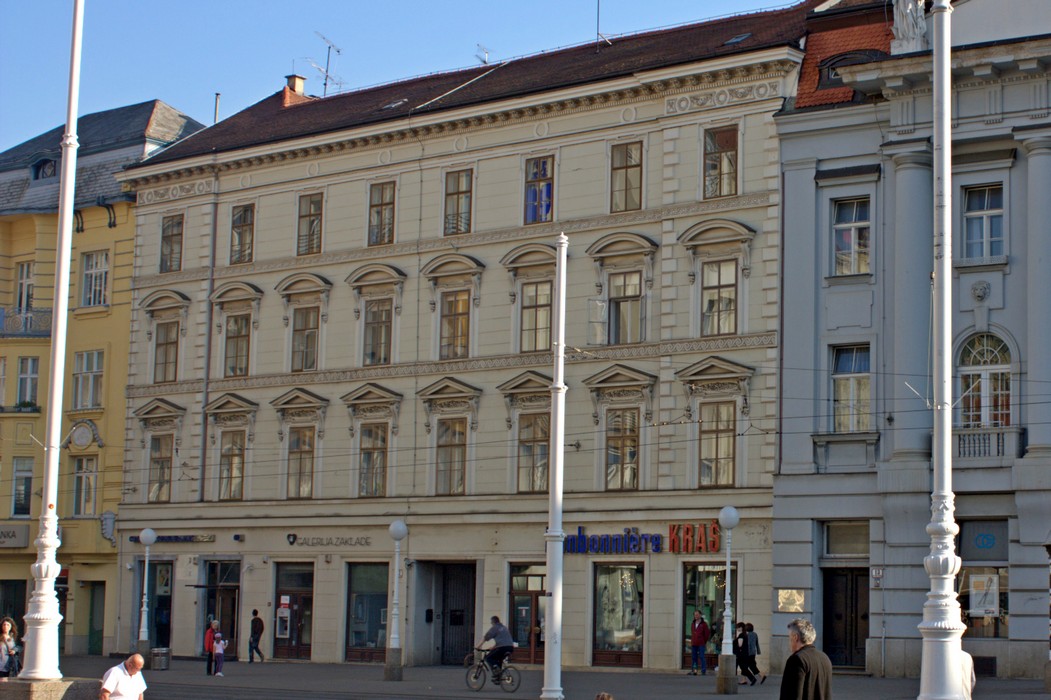 Trg bana Jelačića 12, kuća Živković današnji izgled dobila je 1876. godine. Ivan Plochberger st. projektirao je i izveo nadogradnju i novu fasadu na staroj jednokatnici